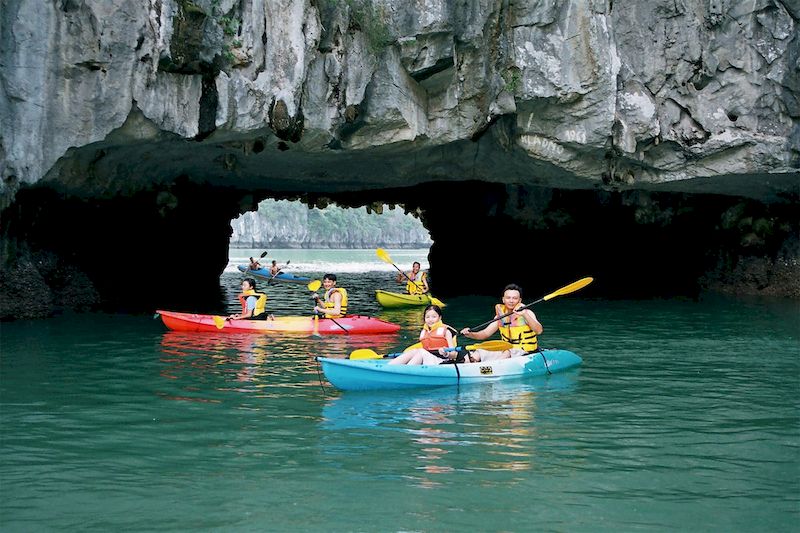 Travelers kayak through Luon Cave