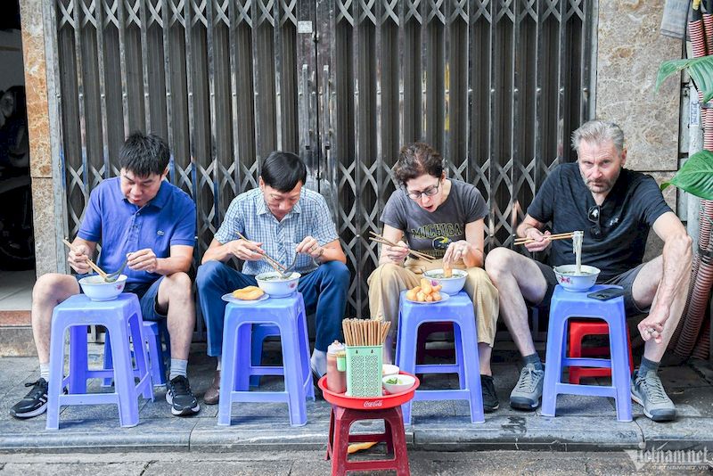 viajeros comiendo sopa pho vietnamita