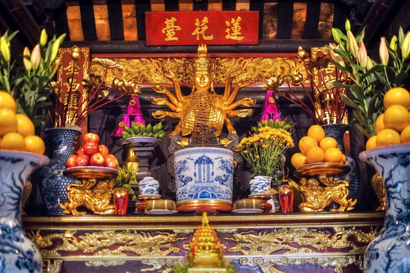 Inside the pavilion, a golden-painted statue of Avalokitesvara is displayed respectfully