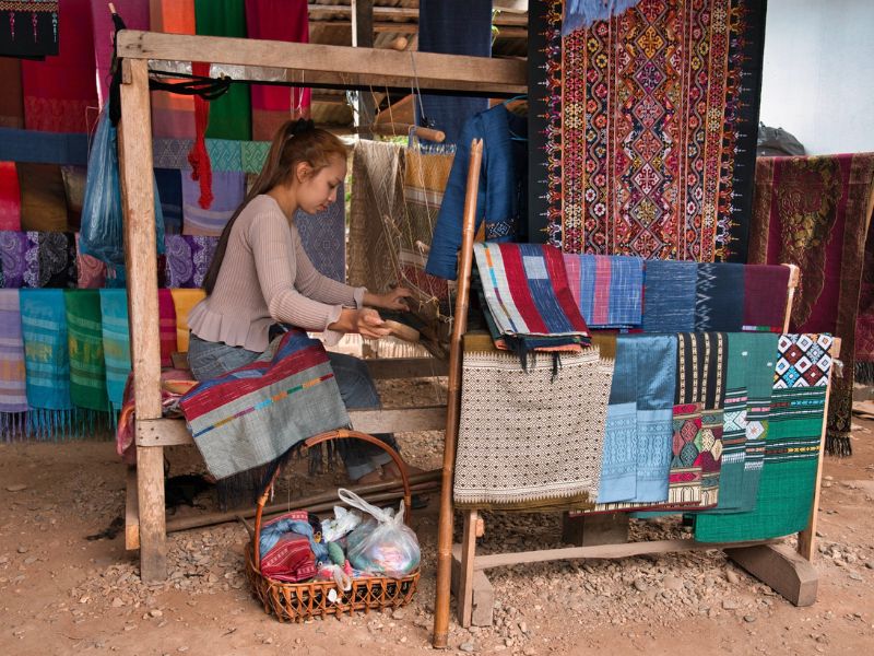 a hmong girl weaving a textile