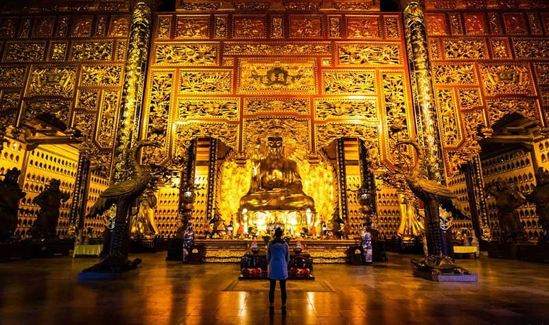 People worship in the Phap Chu Palace of the Bai Dinh complex