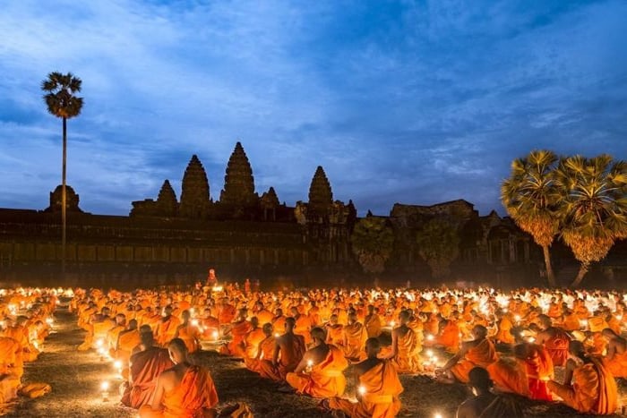 Monks light candles and pray