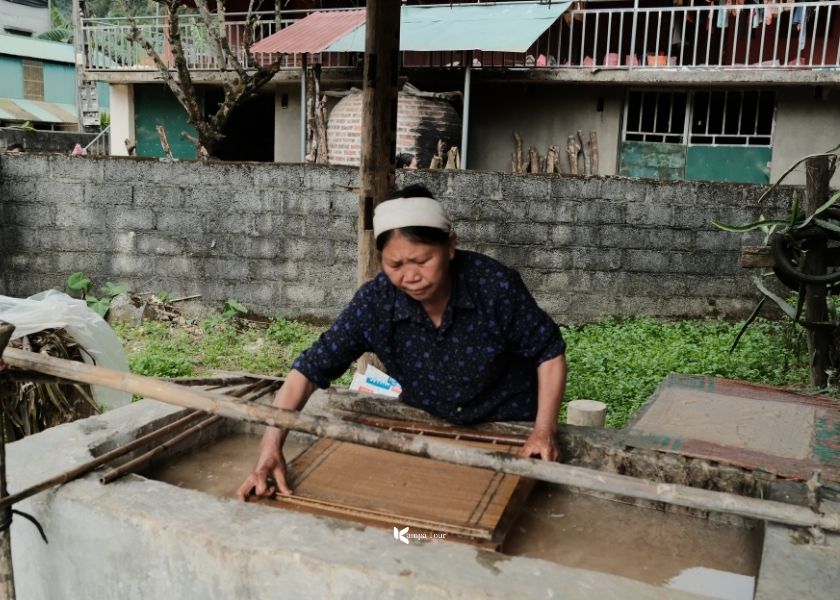 The elderly artisan is showing me how to make a sheet of paper