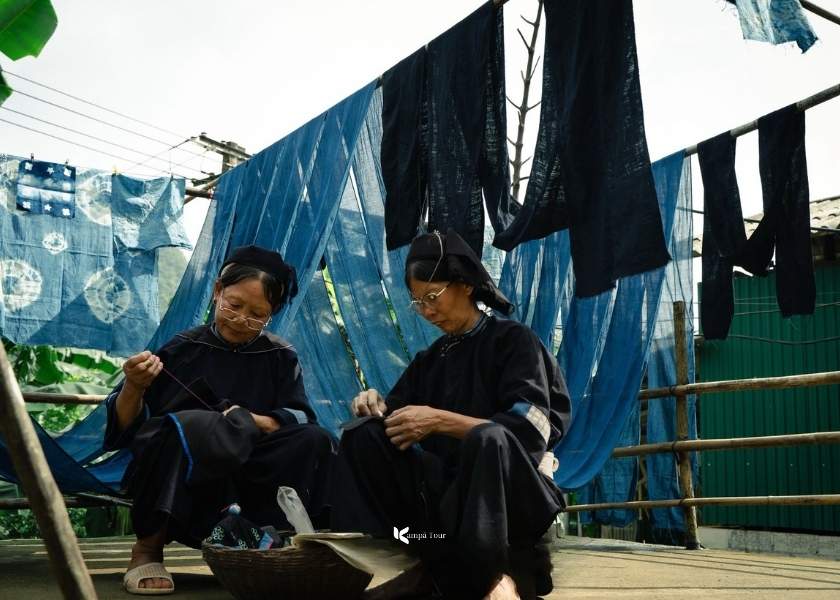 The Nung An woman is embroidering indigo fabric