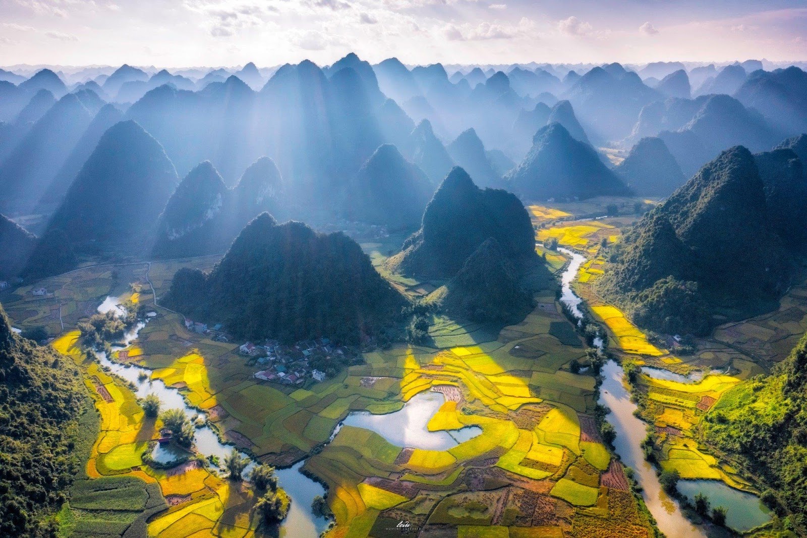 Phong Nam valley's terraced fields and towering karst mountains bathed in dawn's soft glow showcase serene beauty