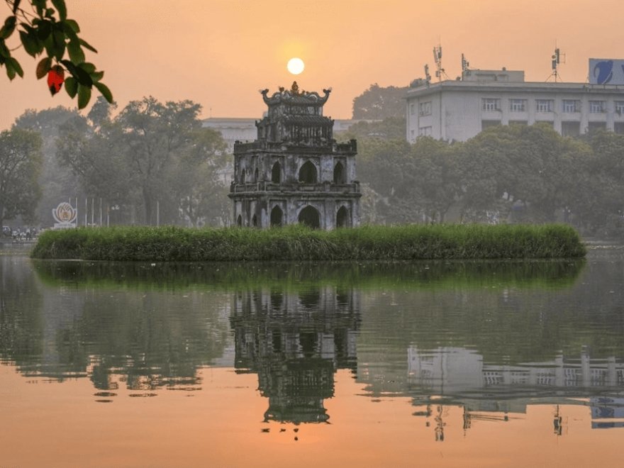 Locals practicing morning exercises at Hoan Kiem Lake at 5:30 AM to beat the June heat.