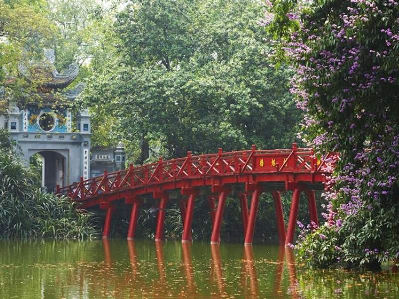Locals walking around Hoan Kiem Lake on a misty March morning