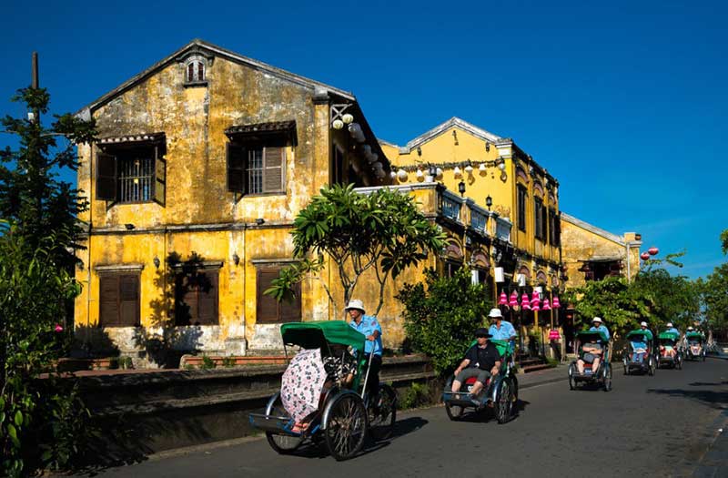 The pedicab moves through the old quarters of Hoi An