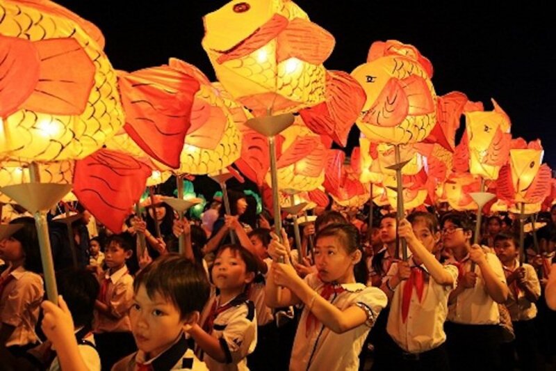 Los niños llevan linternas en forma de carpa, caminan bajo la luz de la luna y cantan canciones del Festival del Medio Otoño