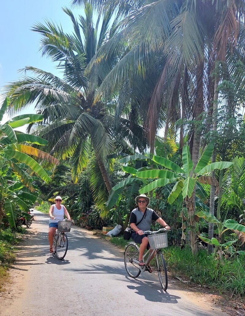 Do you feel like cycling in a peaceful countryside, shaded by refreshing coconut trees, just like our travelers?