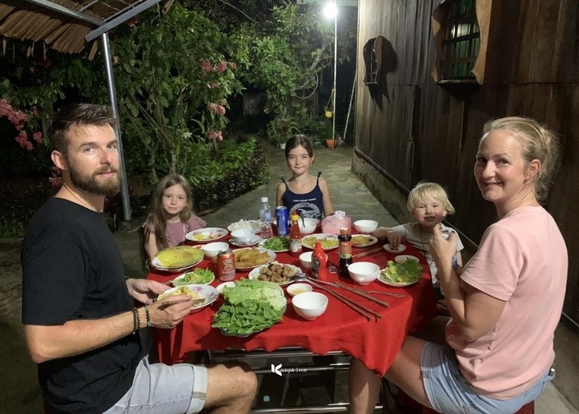 Guests are excitedly experiencing a local dinner at a homestay in Bac Ha