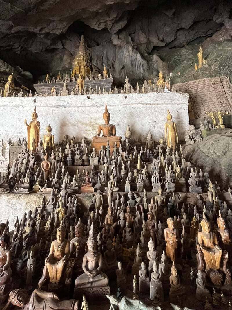 The cave is overflowing with Buddha statues, installed next to each other, until they fill every available space