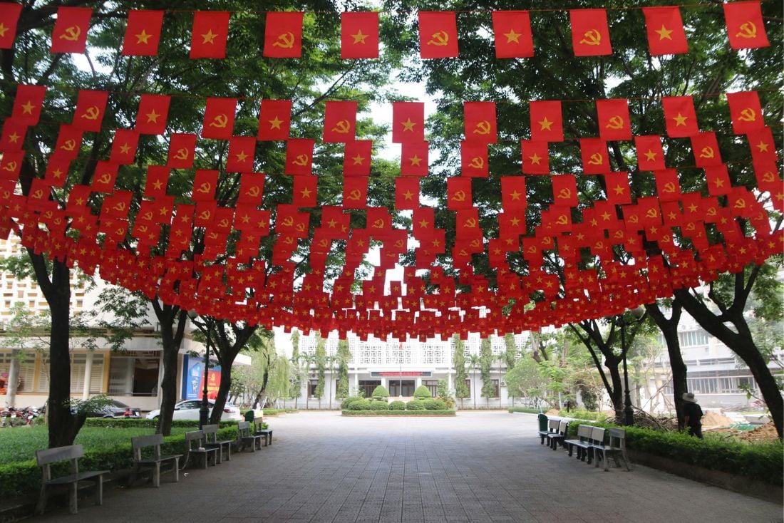 The courtyard of a university in Hue is radiant with the red of the flags