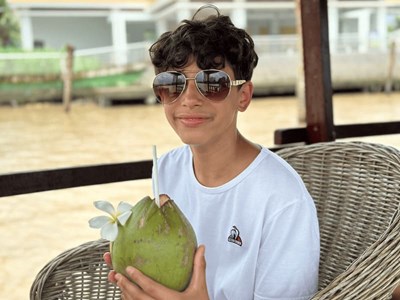 Sipping on fresh coconut water while enjoying a serene boat ride, the perfect way to relax.