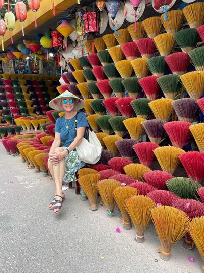 She's sitting among colorful bundles of incense sticks at the vibrant incense village in Hue.