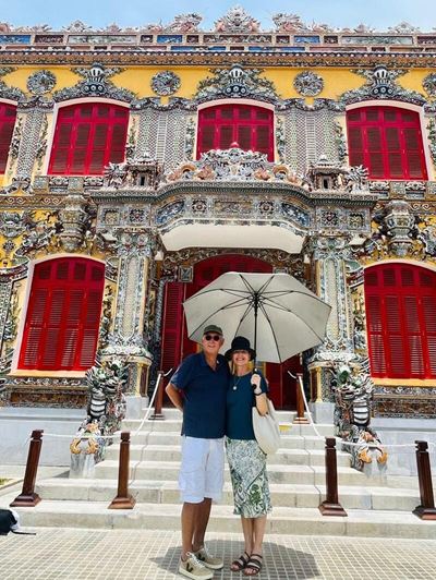 Lane and Oliver in front of Hue Historic Citadel with intricate decorations.