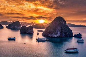 Sunset splendor at Halong Bay: Witness the sky paint golden hues over tranquil waters