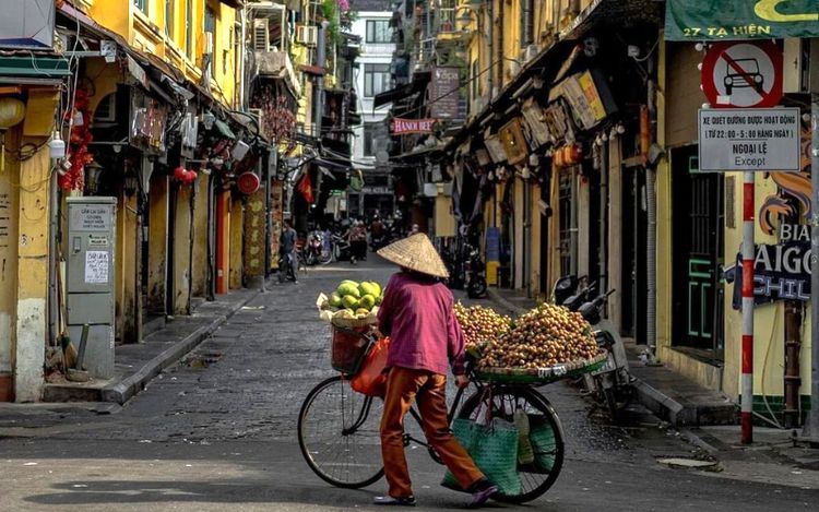 Una vendedora en bicicleta en el barrio antiguo de Hanói