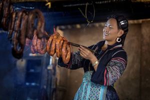 Una mujer Hmong está secando salchichas