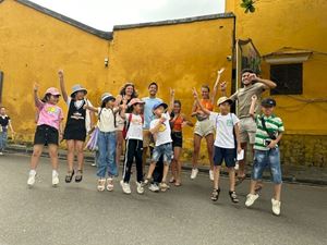 Nuestros queridos viajeros, con los niños locales, en la visita de la ciudad atractiva Hoi An