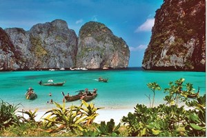 Longtail boats anchored in the crystal-clear waters of Phi Phi Islands, a tropical haven near Phuket.