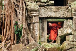 Un monje saliendo de un antiguo templo en Angkor Wat