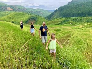 Una familia está explorando los campos en terreza en Sapa