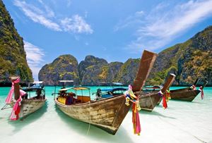 Longtail boats anchored in the crystal-clear waters of Phi Phi Islands, a tropical haven near Phuket.
