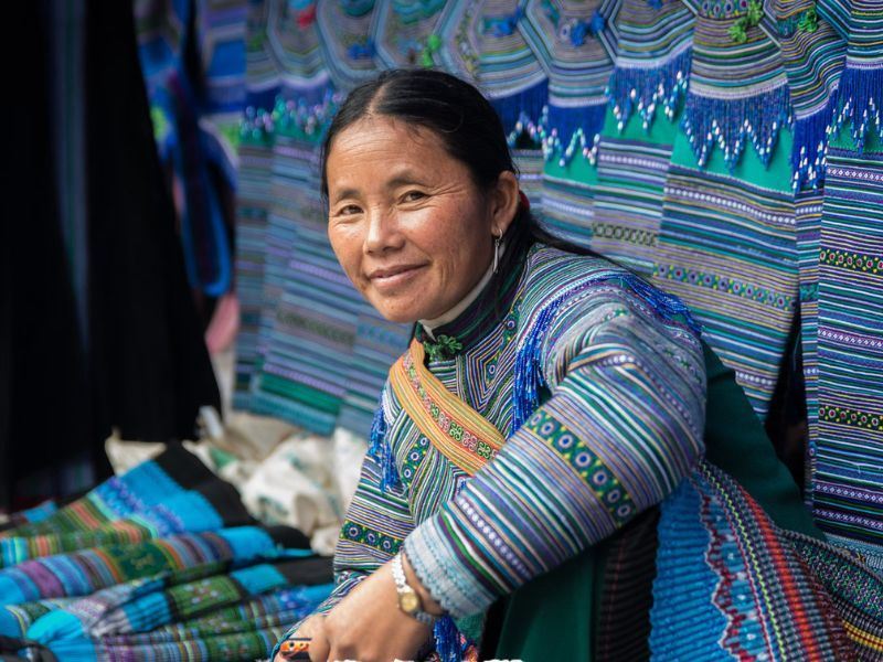Una mujer étnica está vendiendo sus productos de artesanías